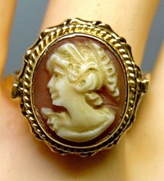 Perfectly crafted carnelian layer stone cameo ring set in 18K gold (stamped 750) Portrait of a woman looking to the left with a finely cut face and curly hair. Elaborate 750 gold version (18K) without missing parts. Very good condition. Playful ring head with ring head size 15x16 mm and a ring inside diameter of 17.5 mm (RG55 = US7) Of course, this piece of jewelry is freshly cleaned and polished in a new jewelry box. worldwide  - Free Shipping -  with tracking number from Germany Antique Cameo Ring Collectible, Gold Oval Cameo Rings, Victorian Gold Cameo Rings, Vintage Gold Cameo Ring, Gold Cameo Ring Jewelry, Antique Cameo Ring In Yellow Gold, Antique Cameo Yellow Gold Ring, Antique Yellow Gold Cameo Ring, Antique Cameo Ring Jewelry