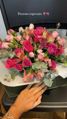 a woman is holding a bouquet of pink roses