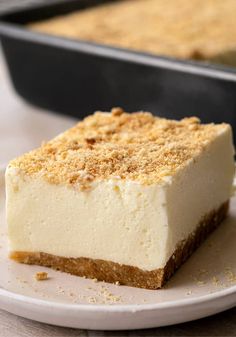 a piece of cheesecake sitting on top of a white plate next to a pan