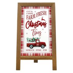 a wooden sign with a red truck and christmas tree on it's side, in front of a white background