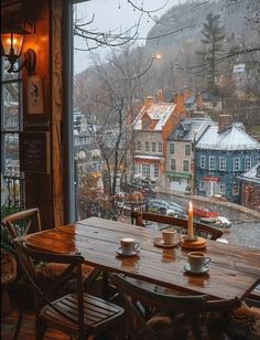 a wooden table sitting next to a window with a view of the town below it