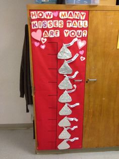 a tall red and silver growth chart with hearts on it, next to a wooden cabinet