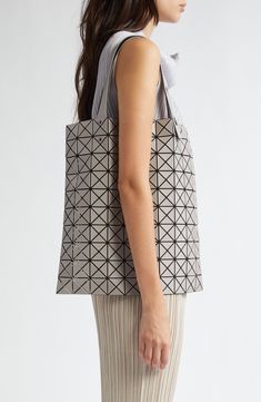 A prismatic array of matte triangles atop flexible mesh transforms this lightweight tote into a unique work of art as it takes the shape of objects inside. The handles adjust for hand or over-the-shoulder carry, while the fluid design allows for easy packing and flat storage when not in use. Open top Adjustable top handles Folds flat for packing or storage PVC/textile Made in Japan Designer Handbags Asian & Pacific Islander Owned/Founded Pacific Islander, Bao Bao Issey Miyake, Bao Bao, Fluid Design, Easy Packing, Fabric Gift Bags, Fabric Gifts, Free Fabric, Issey Miyake