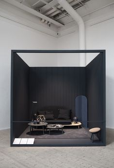 an open room with black furniture and white walls