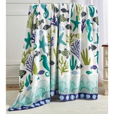 a curtain with sea life on it in front of a white dresser and window sill