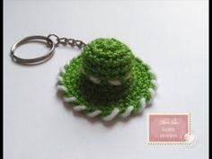 a keychain with a small green object on it's side and a tag attached to it