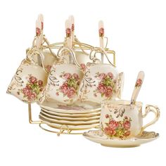 a set of tea cups and saucers with spoons