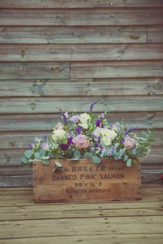 a wooden crate filled with purple and white flowers