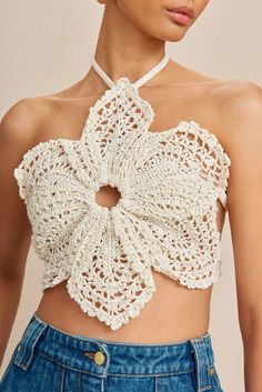 a woman wearing a white crochet top with a bow at the neckline