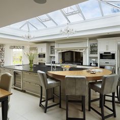 a large kitchen with an island table surrounded by chairs