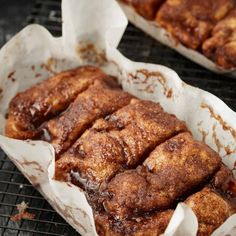 cinnamon rolls sitting on top of a cooling rack next to each other in paper wrappers