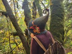 This autumn-inspired felt hat features oak leaves, Hawthorne berries,and amanita mushrooms, topped off with a wooly bear caterpillar crawling up the back. It is made with 100%, sheep's wool, making It both lightweight and extremely durable. The perfect companion for your woodland meanderings.. The hats are made using the ancient technique of wet felting. They are not knitted or upcycled. The process begins with raw sheep wool, which is purchased locally from small family farms. We then wash dye and card it into felting batts, before being hand sculpting and felting them over our original hand-crafted hat forms. Felted wool is considered to be among the world's oldest known textiles. It is both breathable and water-resistant, able to hold up to 40% of its own weight in water before it begin Whimsical Handmade Fall Hats, Hawthorne Berries, Hat Cottagecore, Wooly Bear Caterpillar, Fairycore Clothing, Woolly Bear, Cottagecore Witch, Amanita Mushroom, Angora Goats