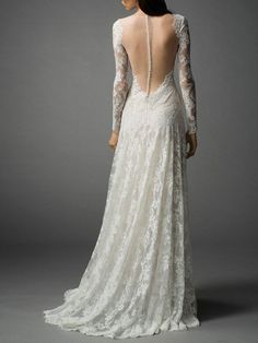 the back of a wedding dress with long sleeves and sheer lace on it, in white