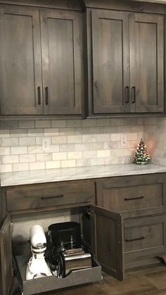 a kitchen with gray cabinets and white counter tops, an open dishwasher in the center