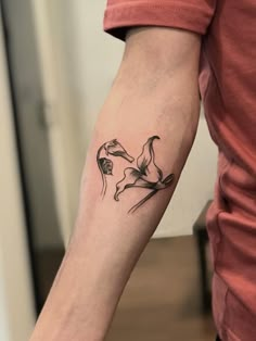 a person with a tattoo on their arm that has flowers in the shape of birds