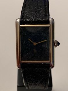 This is an incredibly rare opportunity to acquire a genuine Cartier Le Must wrist watch. With very rare 'sting ray' style black dial. Sterling silver case, hallmarked 925, gold plated with 20mc gold. Additionally verified hallmark by the official Dutch assay mark. The watch is in perfect working condition, keeping very accurate time. Hand winding mechanism, signed Cartier, Swiss, 17 jewels. Original sapphire capuchon crown. All papers with verifying serial numbers. Life time movement guarantee, Black Watch Accessories With Rectangular Dial For Evening, Evening Analog Watch With Rectangular Dial, Vintage Black Watch For Formal Occasions, Vintage Black Watch With Diamond Hour Markers, Black Watch Accessories With Diamond Hour Markers For Evening, Black Watch Accessories With Rectangular Dial For Anniversary, Black Rectangular Dial Watch For Anniversary, Black Polished Finish Watch For Evening, Black Evening Watch With Polished Finish