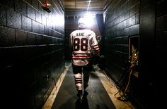 a hockey player is walking down the tunnel