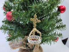 a christmas ornament hanging from the top of a pine tree with ornaments around it