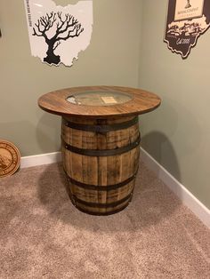 a wooden barrel table sitting on top of a carpeted floor next to a wall