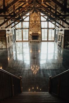 the inside of a large building with stairs leading up to an open floor plan and windows