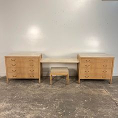 two wooden dressers sitting next to each other in a room with concrete flooring