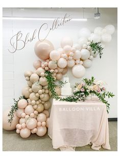 balloons and greenery decorate the backdrop for an event