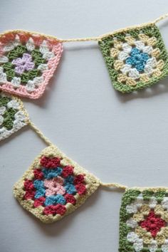 several crocheted squares are hanging on a string