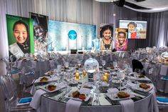 a banquet room set up with round tables and clear chairs