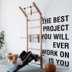 a man is doing an exercise on a gym equipment in front of a wall that says the best project you will ever work on is you