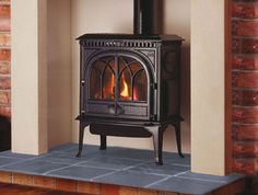 a wood burning stove in a brick fireplace