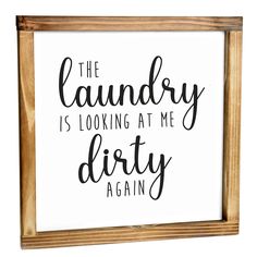 the laundry is looking at me dirty again sign in a wooden frame on a white background