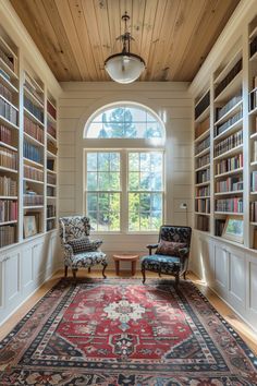 a room with two chairs and a rug in front of a window filled with books