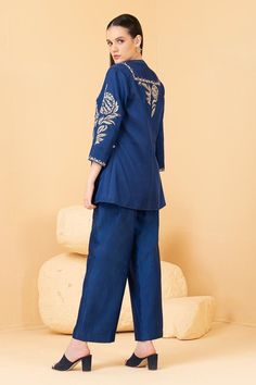 Blue jacket featuring zari embroidered floral motifs embellished with sequins. Comes with plain chanderi pant and inner top.
Components: 3
Pattern: Embroidered
Type Of Work: Zari, Pearl, Sequin
Neckline: Jacket: Open, Top: Band Collar
Sleeve Type: Jacket: Three quarter
Fabric: Top and Pant: Chanderi, Jacket: Modal Satin
Color: Blue
Other Details: 
Attached lining
Length: Jacket sleeve: 18 inches
Weight: 1.5 kgs
Closure: Inner Top: Front button
Occasion: Cocktail,Reception - Aza Fashions Top Band, Cocktail Reception, Satin Color, Embroidered Jacket, Band Collar, Blue Top, Floral Motifs, Open Top, Blue Jacket