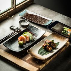 a table topped with different types of plates and bowls filled with food next to each other