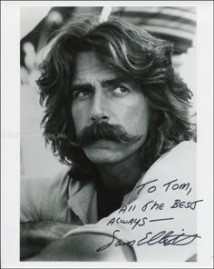 a man with long hair and a moustache on his face is posing for a photo