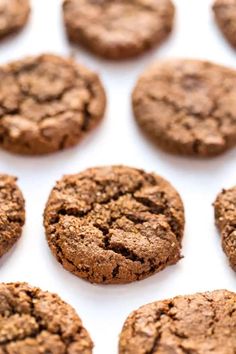 chocolate cookies are arranged in rows on a white surface