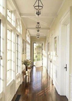 a long hallway with white walls and wood floors