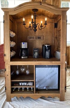 a wooden cabinet with coffee and wine on it