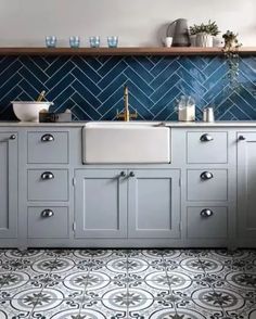 a kitchen with blue and white tiles on the walls, cabinets and countertops