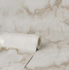 a roll of white marble paper sitting on top of a table next to a wall