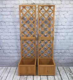 two wooden planters sitting next to each other on top of a white brick wall