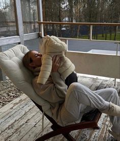 a woman sitting in a chair on the porch