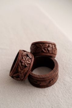 two wooden rings sitting on top of a white cloth