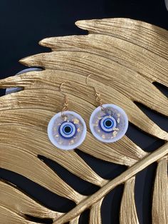 "Elegant and beautiful Evil eye earrings made with an eye-relaxing mix of clear and white colors with an evil eye charm, and using hypoallergic earing hooks. A great match for a wide range of outfits, colors and styles. Handmade and made especially for you. - Material: High quality Resin, Evil eye charm and hypoallergic earing hooks - Light weight and durable: That is what Resin is about after all - Artistic, creative style and fine finish. - Great for casual occasions, everyday wearing, also ca White Evil Eye Dangle Jewelry, Resin Evil Eye, Jewelry Photos, Evil Eye Earrings, Eye Earrings, Of Outfits, Evil Eye Charm, Resin Earrings, White Colors