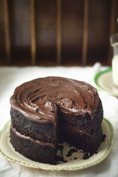 a chocolate cake on a plate with one slice cut out