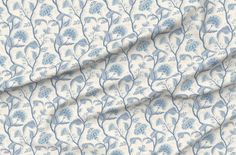 a blue and white floral print fabric with small leaves on the side, in front of a ruler