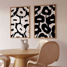 two black and white paintings hang above a table