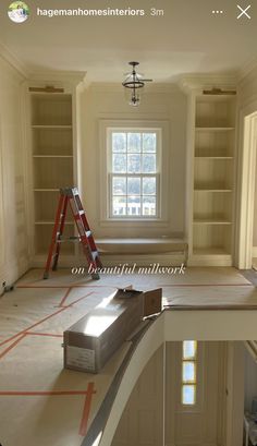 an empty room with ladders and boxes on the floor