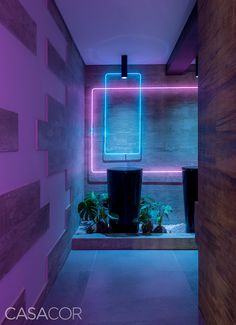 a room with purple lighting and plants in the corner