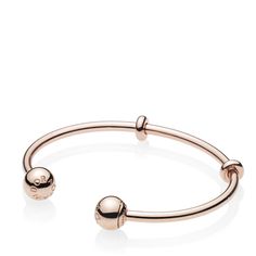 A sleek addition to your jewelry box, Pandora's 14K rose gold-plated Pandora Moments Open Bangle is minimally detailed with silicone stoppers that double as adornments. The polished style is plated with 14K rose gold for a warm finish. The logo-embossed end caps are easily removed to add charms — and are interchangeable to suit your mood. Modern Adjustable Rose Gold Bracelets, Adjustable Modern Rose Gold Bangle, Classic Adjustable Rose Gold Bangle, Pandora Logo, Pandora Rose Gold, Open Bangle Bracelet, Pandora Rose, Polished Style, Bracelet Pandora